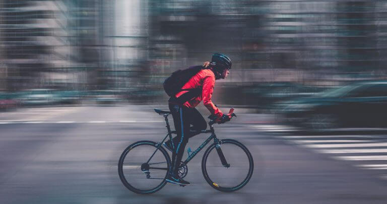 cyclist with blurred city background